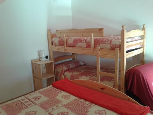 two bunk beds in a room with a surfboard on a bed at Agriturismo Botton D'Oro in Dongo