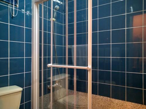 y baño con ducha de azulejos azules. en The LEY HOTEL 寶麗頌旅館, en Tainan