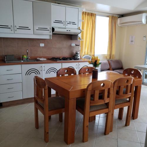 a kitchen and dining room with a wooden table and chairs at Arco Iris Atacames in Atacames