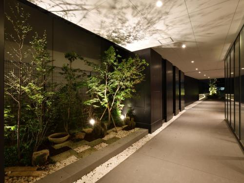 um corredor com plantas ao lado de um edifício em Hotel Keihan Sendai em Sendai