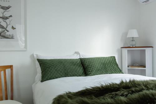 a bedroom with a bed with green and white at The Rested Guest 3 Bedroom Cottage West Wyalong in West Wyalong
