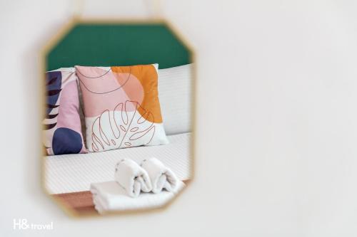 a mirror reflection of a bed with towels at Sleepier Multi-Minsu Tainan in Tainan