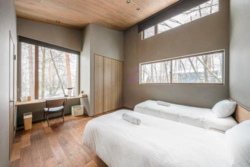白馬村にあるグラビティ by ザ・ハクバ・コレクションのベッドルーム1室(ベッド2台、窓2つ付)
