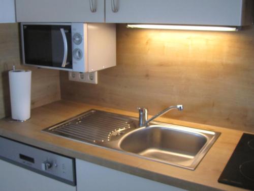 a kitchen counter with a sink and a microwave at Haus Landl in Haus im Ennstal