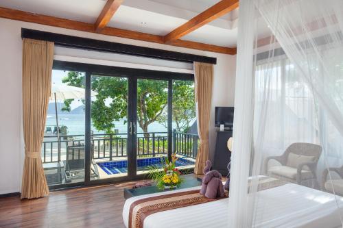 una camera da letto con un letto e vista sull'oceano di Phi Phi Long Beach Resort & Villa a Phi Phi Don