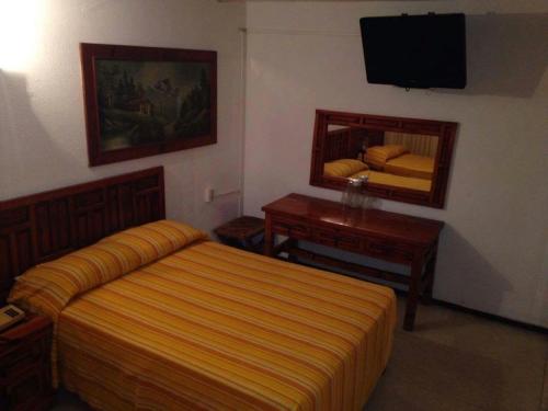 a hotel room with a bed and a mirror at Hotel Maria Luisa in Iguala de la Independencia