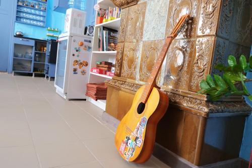 a wooden table topped with a guitar next to a window at Мини-отель Backpack in Kazan