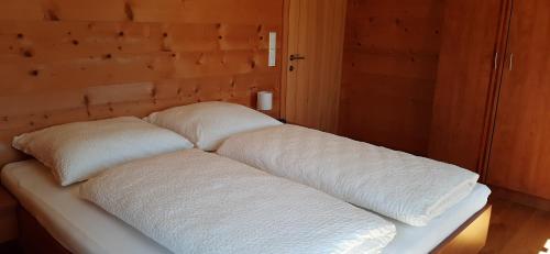 eine Couch mit weißen Kissen darüber in der Unterkunft Ferienwohnung Schönenbühl in Hittisau