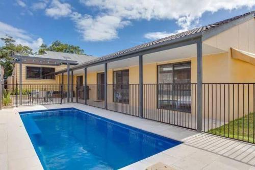 a house with a swimming pool next to a building at Charmes, paradise by the shore in Tootgarook