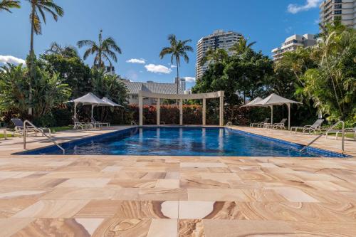 a swimming pool in a resort with palm trees at Contessa Holiday Apartments in Gold Coast