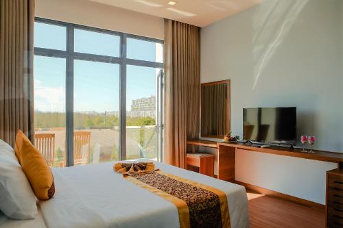 a hotel room with a bed and a large window at Ivory Phu Yen Hotel in Tuy Hoa