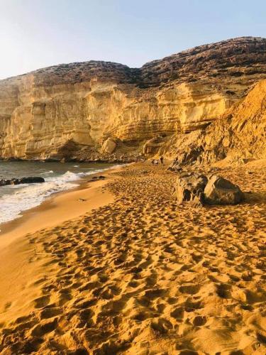 a sandy beach with rocks and the ocean at Fantastic Matala 2 in Matala