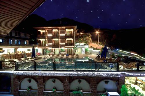 a building with a swimming pool at night at Hotel Azmakhan in Akyaka