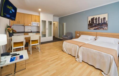 Habitación de hotel con cama y cocina en Hotel Apartamentos Dabarca, en Pontevedra