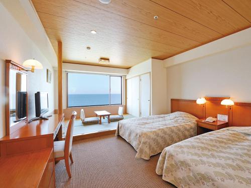 a hotel room with two beds and a large window at Ryugujo Spa Hotel Mikazuki Ryugutei in Kisarazu