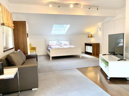 a living room with a couch and a television at Auszeit im Chiemgau, Ferienwohnungen in Rottau