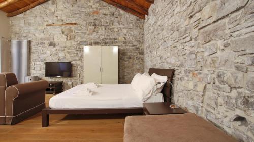 a bedroom with a bed and a stone wall at Italianway - Torno in Torno