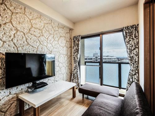 a living room with a couch and a large window at Terrace Resort Chatan West in Chatan