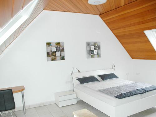 ein Schlafzimmer mit einem weißen Bett und einer Holzdecke in der Unterkunft Ferienwohnung Sylvianne in Ottenhöfen