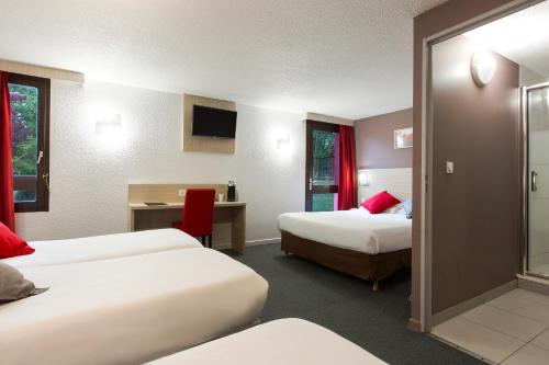 a hotel room with two beds and a desk at HOTEL EDEN - Metz Nord in Woippy