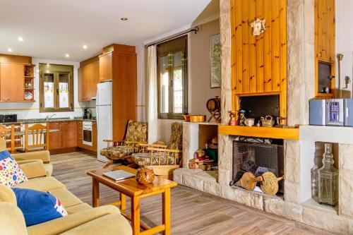 a living room with a fireplace and a kitchen at Cal Soi in Lleida