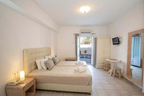 a bedroom with a large bed and a bathroom at Erato Apartments in Firostefani