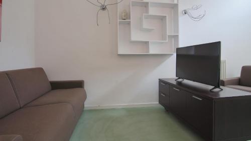 a living room with a couch and a flat screen tv at Italianway - Torno in Torno