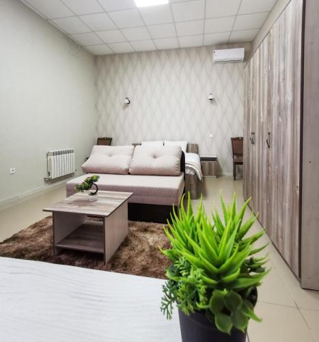 een woonkamer met een bank en een tafel bij Tarlan Hotel in Aqtau