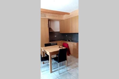 - une cuisine avec une table et des chaises en bois dans l'établissement La casa sul parco, à Grosio
