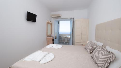 a bedroom with a bed with white sheets and pillows at Erato Apartments in Firostefani