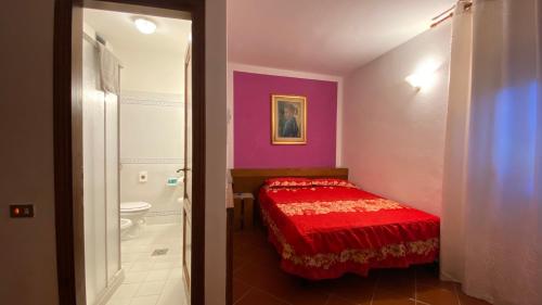 1 dormitorio con cama roja y baño en MOTORRADHOTEL TOSKANA - Il Molino del Ponte - Minimum 3 Nächte, en Montespertoli