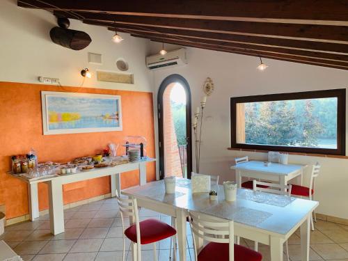 a kitchen with white tables and chairs and a window at B&B Al Fondaco in Pescantina