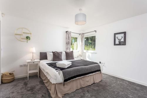 a white bedroom with a bed and a window at Walker Suite No82 - Donnini Apartments in Kilmarnock