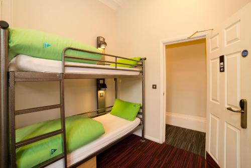a bunk bed room with two bunk beds with green pillows at YHA Castleton Losehill Hall in Castleton