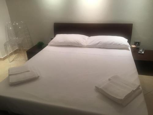 ein großes weißes Bett mit zwei Handtüchern darauf in der Unterkunft TraMura in Trapani