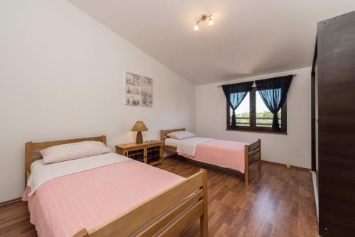 a bedroom with two beds and a window at Apartment Astoria in Zaton