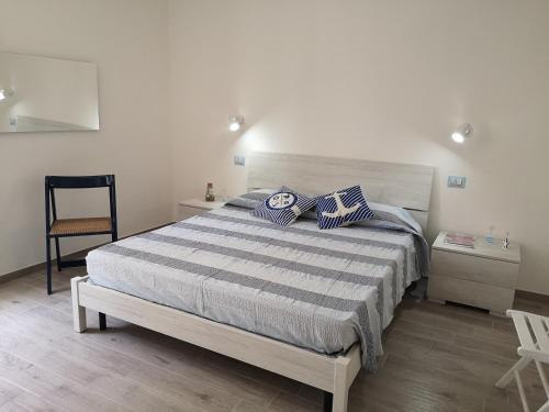 a bedroom with a bed and a chair in it at Casa di Giò - Alghero in Alghero