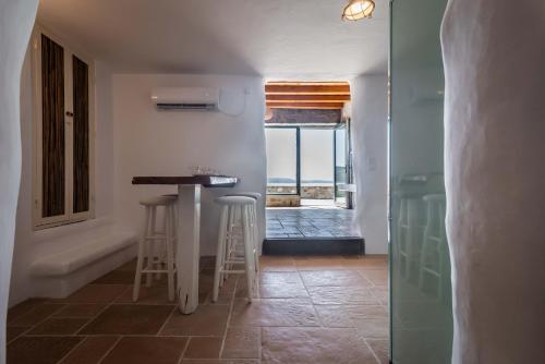 a kitchen with a counter and stools in a room at Petra Residence Mini Pool Spa in Adamas