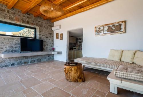 a living room with a couch and a tv at Petra Residence Mini Pool Spa in Adamas