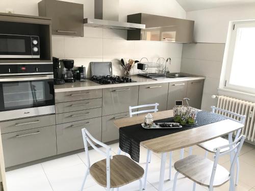 une cuisine avec une table et des chaises dans une cuisine dans l'établissement O SONHO CasaSavernoise appart1, à Saverne