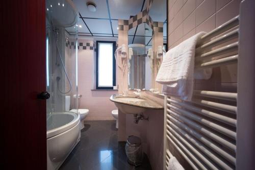 a bathroom with a sink and a tub and a toilet at Hotel Verri in Misano di Gera dʼAdda