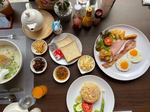 een tafel met borden voedsel met eieren en brood bij GREENHILLS RESORT Si Racha in Ban Nong Wa