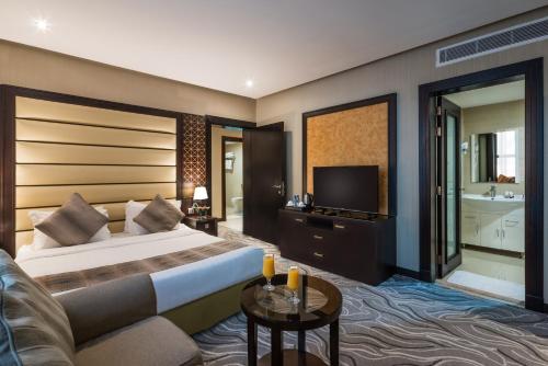 a hotel room with a bed and a television at Naviti Warwick Al Khobar in Al Khobar