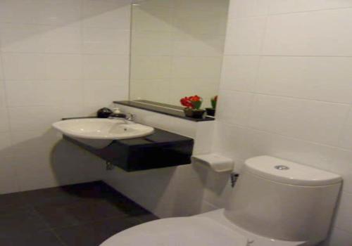 a bathroom with a white toilet and a sink at The Atrium Ratchada 13 in Bangkok