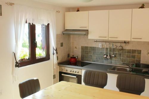 a kitchen with white cabinets and a sink and a table at NERRO in Prezid
