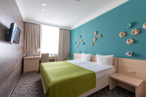 a bedroom with a bed, a desk, and a painting on the wall at Business Hotel Diplomat in Nizhny Novgorod