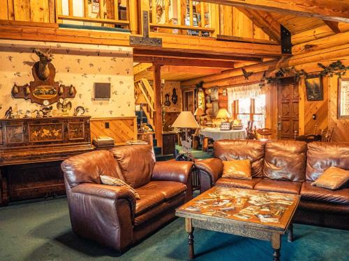 a living room with leather couches and a table at Eagle's Nest in Big Bear Lake