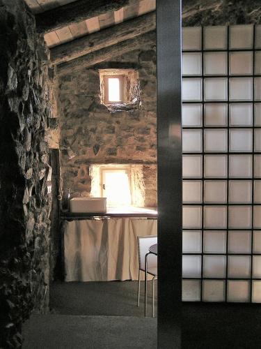 une chambre avec une table et deux fenêtres dans l'établissement La Grande Maison á Chanteuges, à Chanteuges