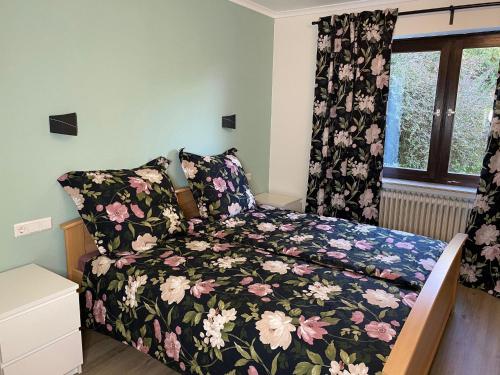 a bedroom with a bed with a floral bedspread at Ferienwohnung Birkenhof in Drolshagen