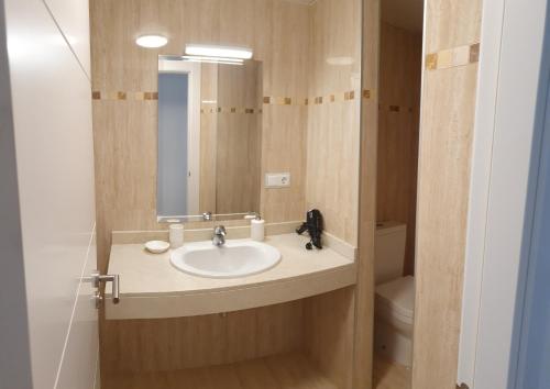 a bathroom with a sink and a mirror and a toilet at Golf & Beach La Alcaidesa Terrace in San Roque